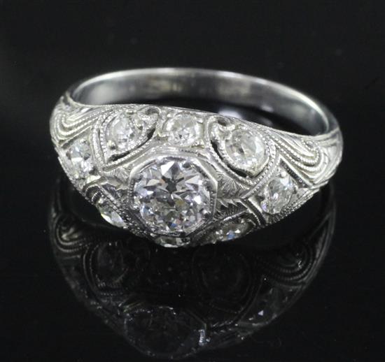 A mid 20th century pierced platinum? and diamond bombe cluster ring, size O.